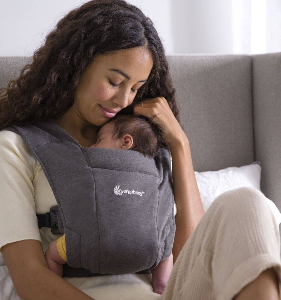 Ergobaby Embrace - Heather Grey baby carrier with woman holding newborn closely | Babymaxi