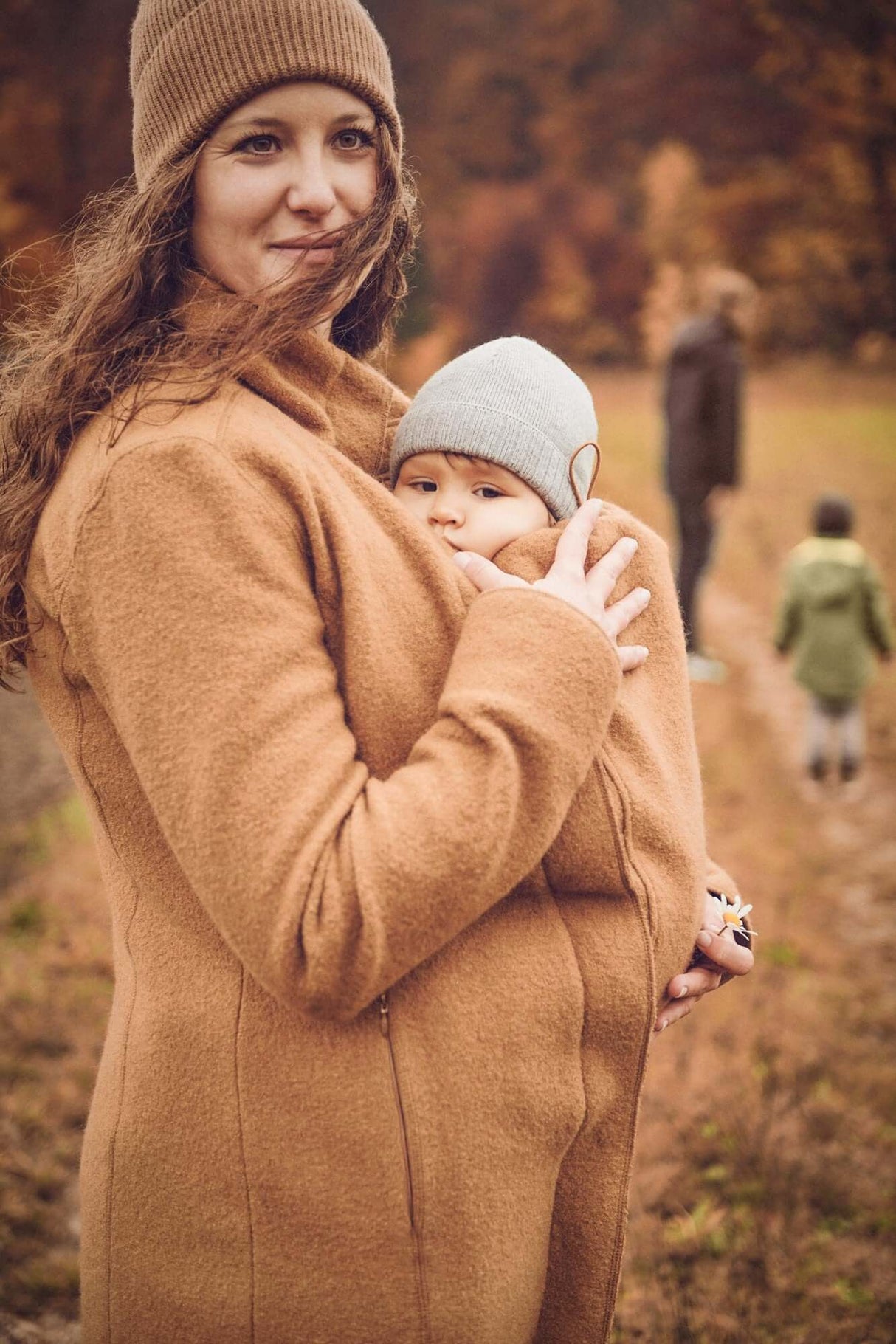 Mamalila Eco Wool Babywearing Coat Oslo - Camel worn by a mother holding a baby, perfect for pregnancy and babywearing | Babymaxi
