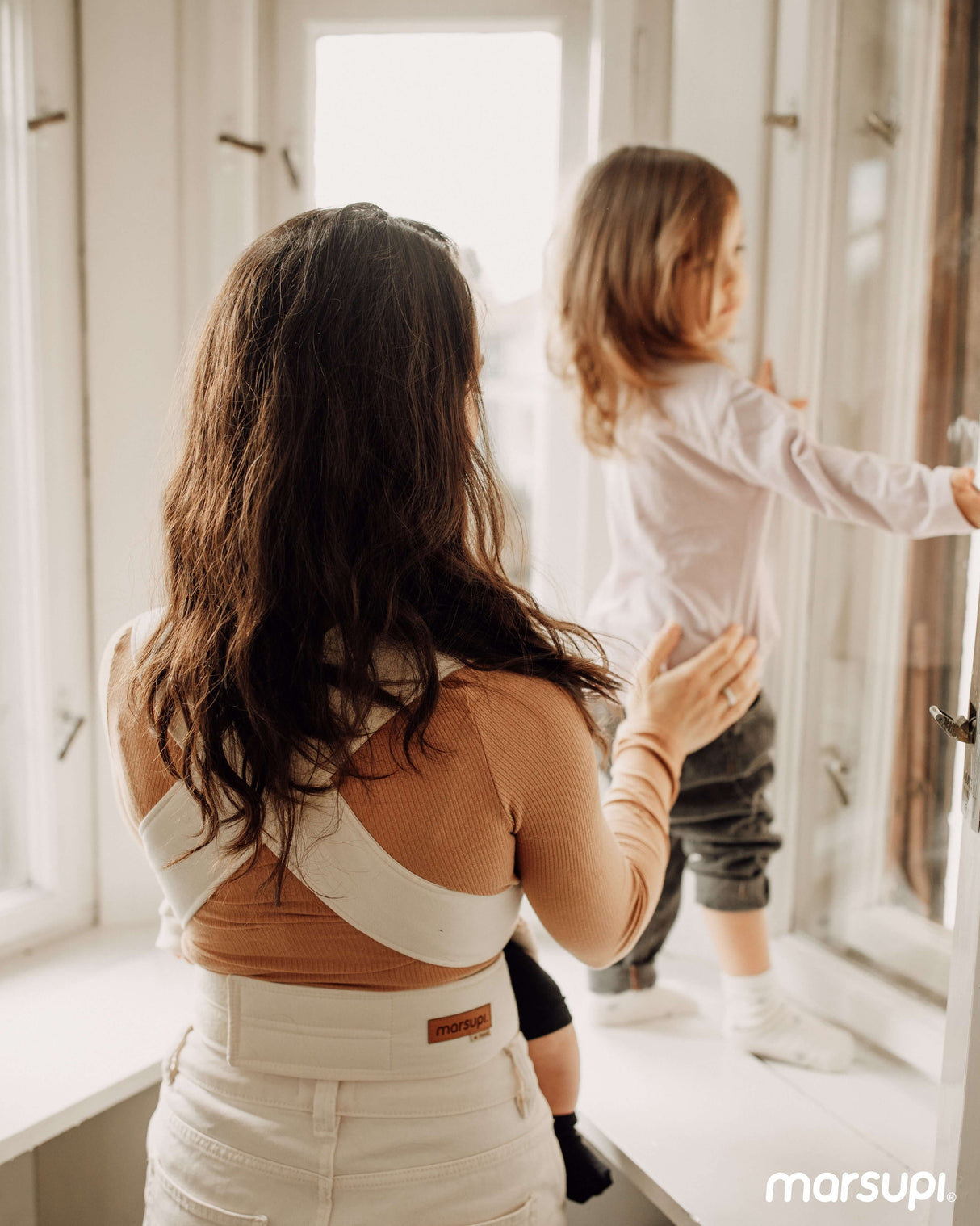 Mom using Marsupi Classic - Natur baby carrier, standing with child by window | Babymaxi