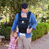 A dad wearing the Ergobaby Adapt - SoftFlex Mesh: Midnight Blue baby carrier with a baby in front and a girl beside him | Babymaxi