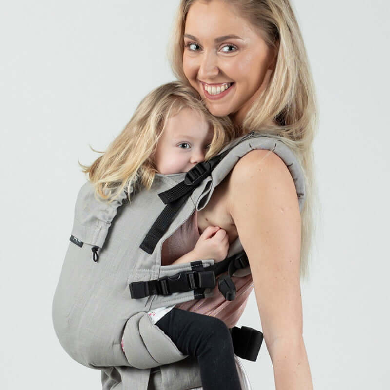 Isara The One - Misty Linen baby carrier in sage green, soft and breathable, worn by a smiling parent with a child | Babymaxi
