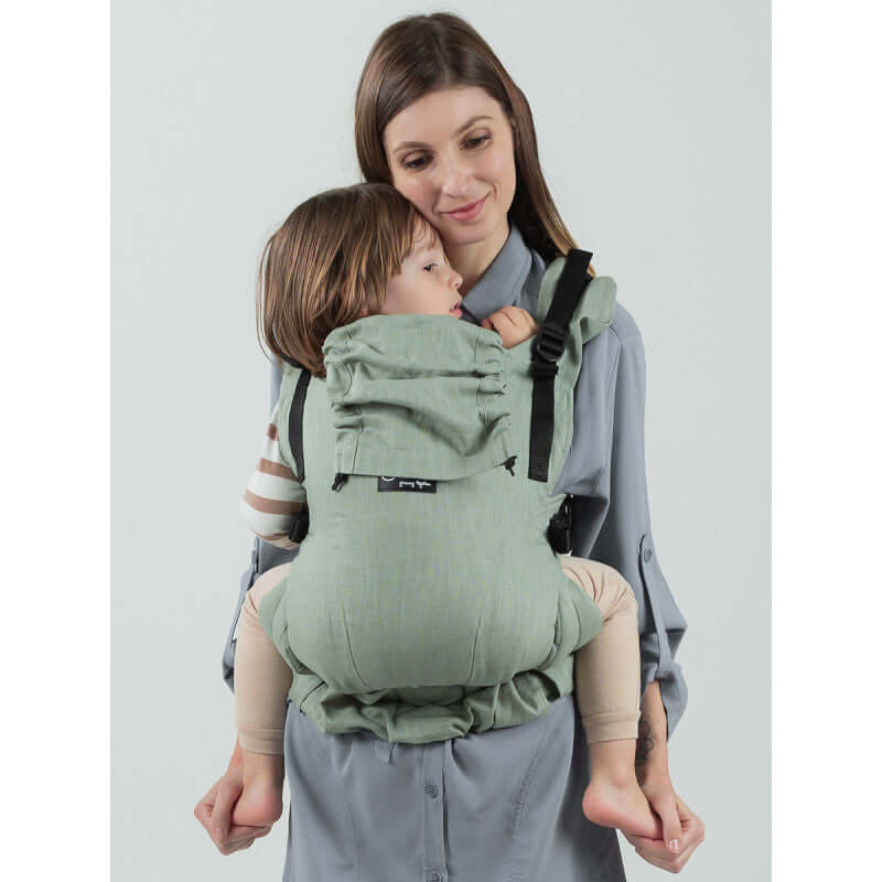 Isara The One - Sage Green Linen baby carrier worn by a parent, showcasing ergonomic design and soft linen fabric | Babymaxi