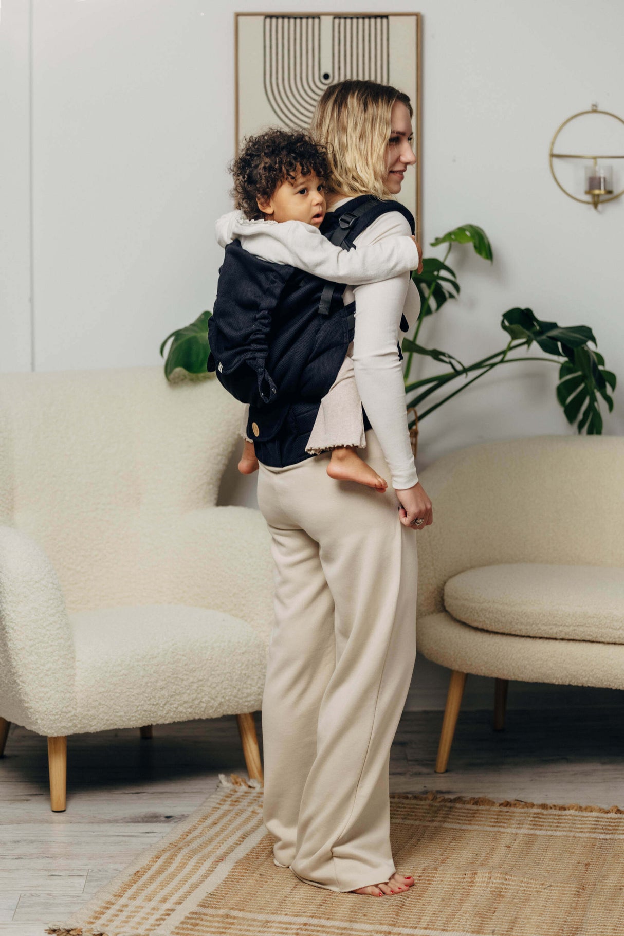 LennyLamb LennyPreschool (up to 30kg) - Little Herringbone Ebony Black toddler carrier with child, stylish indoor setting | Babymaxi