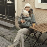 Mamalila Boston Babywearing Jacket - Agave worn by mother carrying baby, stylish and practical for motherhood | Babymaxi