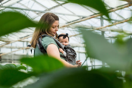 Neko Switch Baby Carrier - Bold, 2 extra hoods being used in a greenhouse with a parent and baby | Babymaxi
