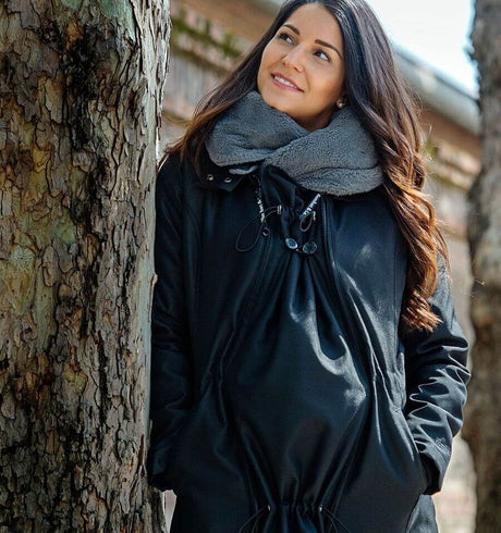 Wombat & Co. London - Wallaby Babywearing Jacket – Black & Charcoal worn by a woman outdoors | Babymaxi