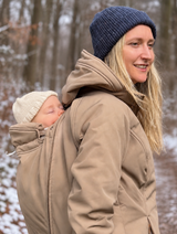 Mamalila Allrounder Winter softshell babywearing jacket in chestnut brown, mum carrying her baby on her back on a snowy walk